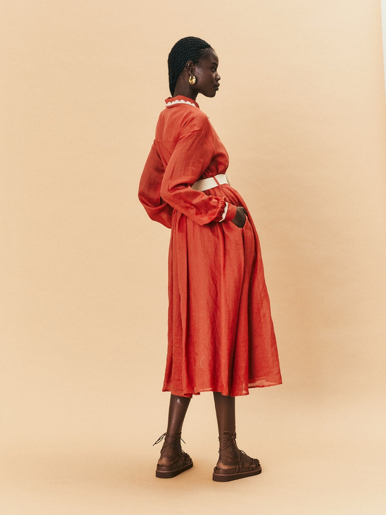 A young woman wearing La Maise Lyon Shirt Maxi Dress in rust red.