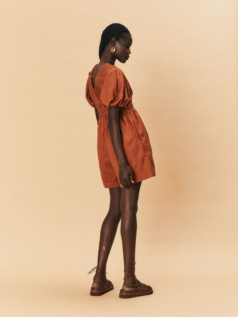 A young woman wearing La Maise Le Havre Romper in rust brown.