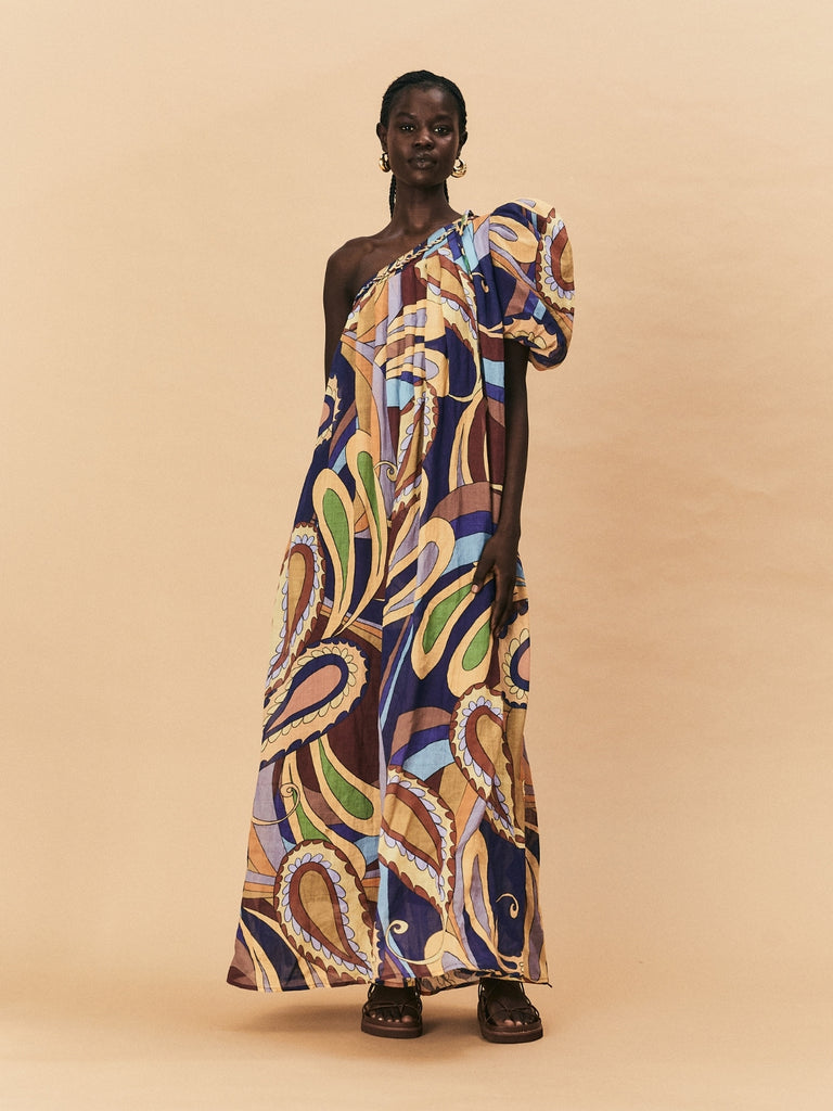 A young woman wearing La Maise Dijon Maxi Dress against a beige background.