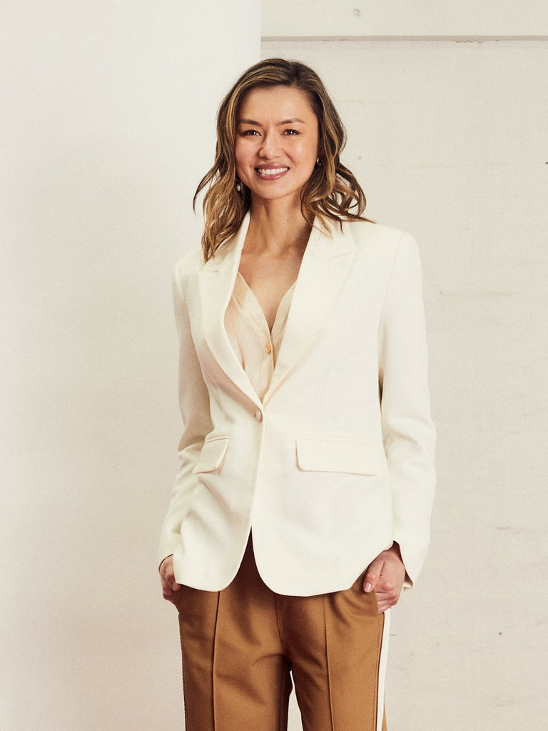 Woman wearing a white We Are The Others Jules blazer blazer and brown Alba pants against a plain background