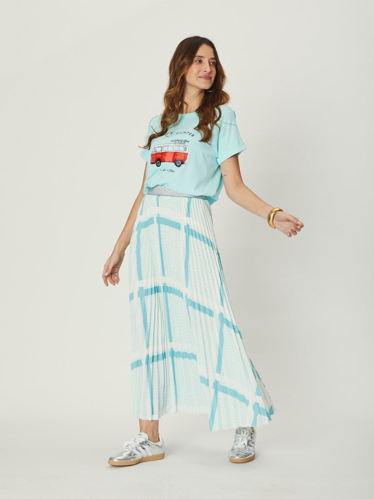 Side view of the Simone Pleat Skirt in teal base, highlighting its fluid movement, bold check pattern, and ankle-skimming length.
