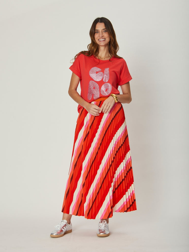 Full-length view of the Simone Pleat Skirt in red and pink stripe, highlighting its flattering silhouette and movement.