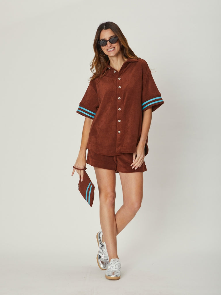 Back view of the Stephanie Towelling Shirt in brown, featuring a loose fit, short sleeves with contrasting stripes, and coordinating shorts for a summer look.