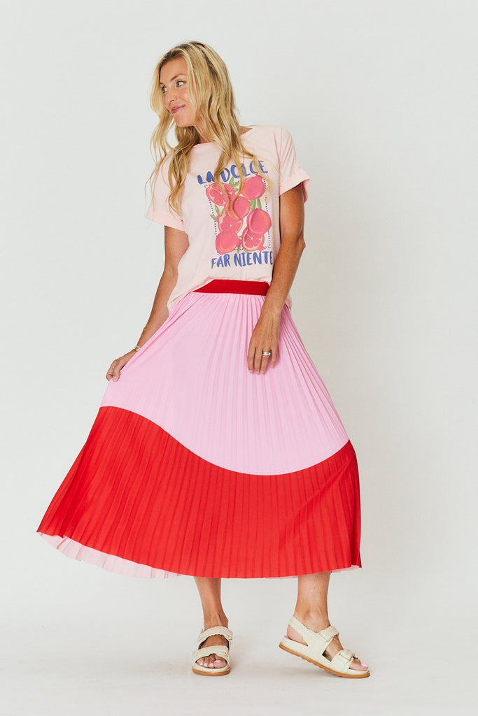 Woman wearing a pink and red dress with a graphic t-shirt on a white background